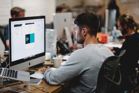 man on computer designing sales development representative compensation plan
