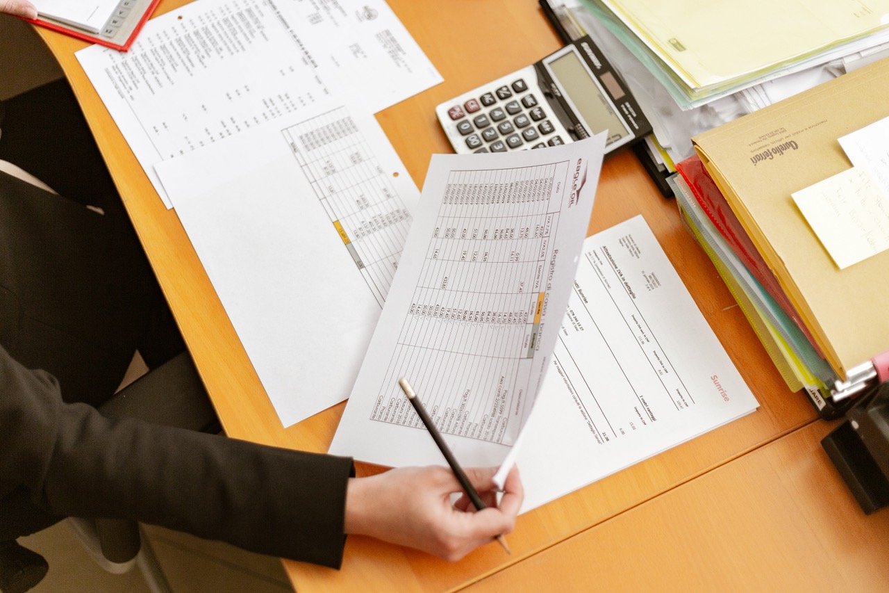 person-holding-white-printer-paper-and-pen-2058136