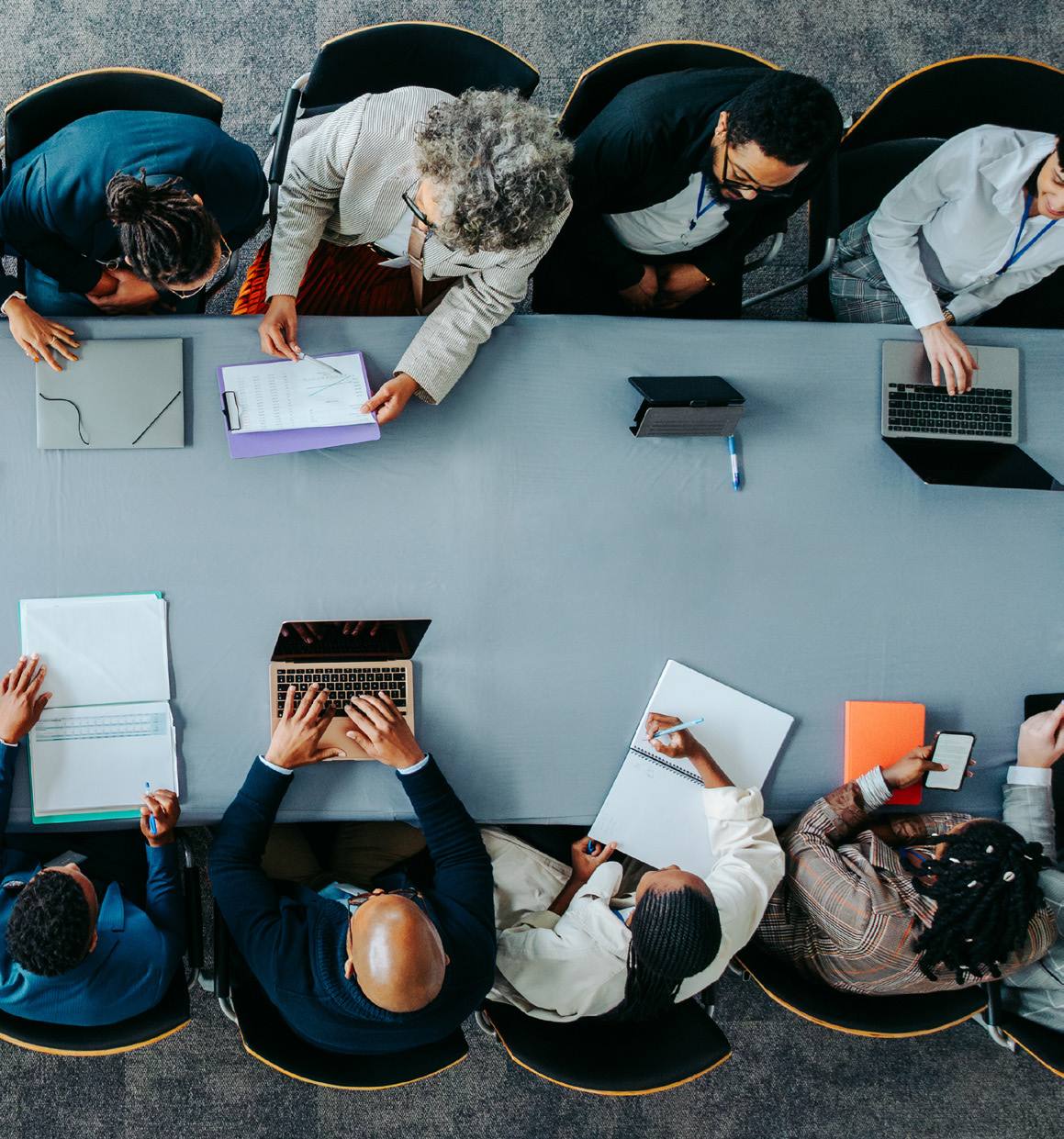 Overhead view of a cross-functional team working together around a long conference table.