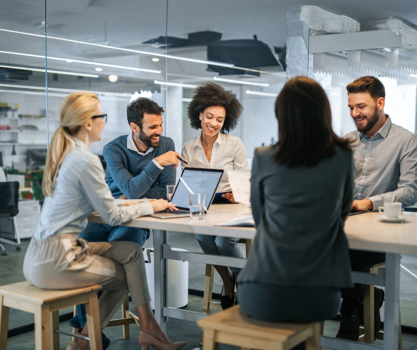 A revenue team collaborates around a table in a bright office.