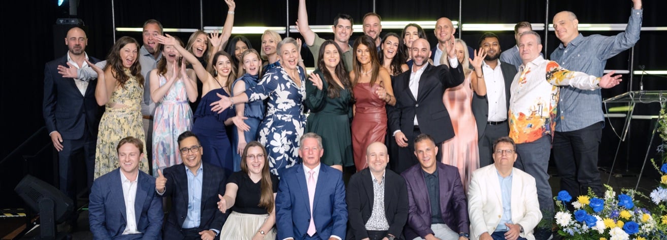 Varicent team members celebrating together on stage at a company event